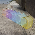 Rows of miniature brightly coloured Beach Huts in hollow cast lead crystal glass...